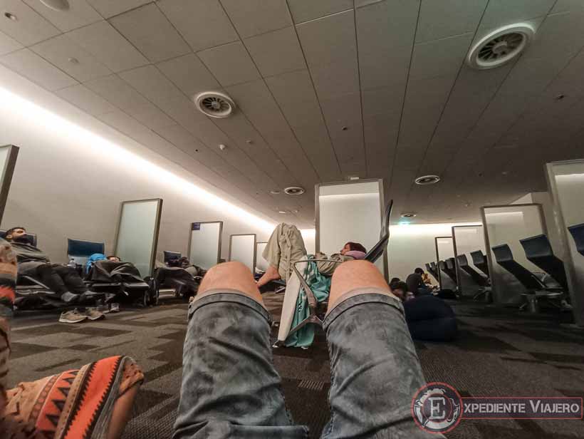 Tirados en el suelo en la sala de descanso al hacer la escala en Doha