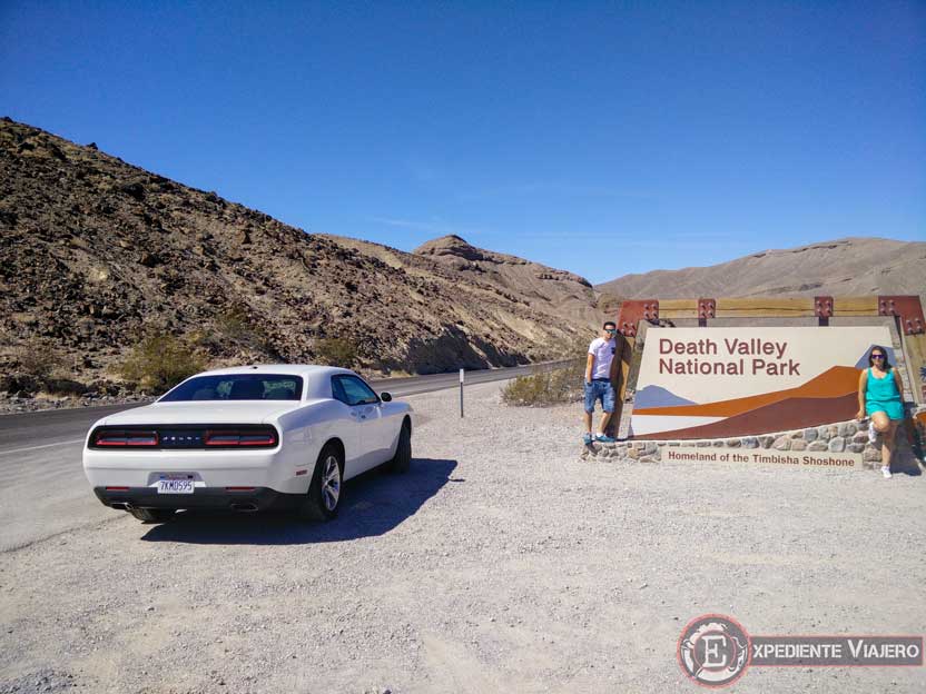 Junto a un coche blanco en Death Valley en un viaje en coche por la costa oeste de Estados Unidos
